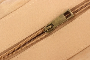 Close-up of vintage bronze zipper and thick khaki woven fabric texture on handbags