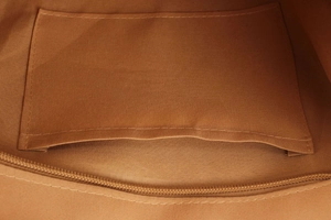 Macro shot of the durable fabric inner lining and internal pocket storage of a woven bag