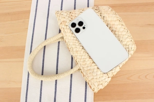 Detail view of woven straw bag showing internal capacity with a smartphone inside