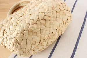 Detailed macro view of woven corn husk straw bag texture with thick rope handle