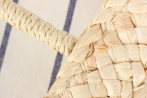 Close-up of thick woven corn husk handle detail on a natural handmade beach tote bag
