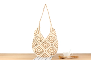 Detail of hand-crocheted shoulder bag featuring vintage hollow floral pattern and wavy edges