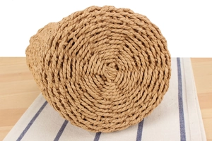 Close-up of spiral woven paper rope craftsmanship on the bottom of a straw bucket bag