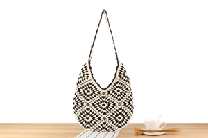 Detail of handmade crochet shoulder bag with black and white geometric floral patterns