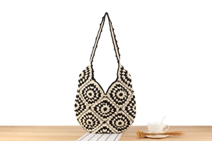Detailed close-up of a handmade crochet granny square tote bag in black and white
