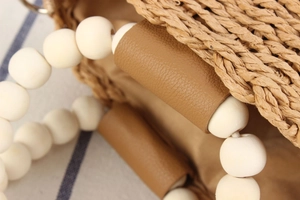 Detailed macro of woven paper rope texture with wooden bead handle and leather buckle