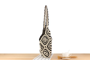 Detail of hand-woven crochet tote bag with vintage black and white floral patterns
