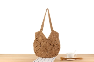 Detail of hollow diamond pattern on khaki woven tote bag on a wooden table