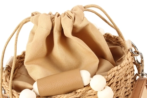 Detail of woven straw bucket bag with bead handle, cotton drawstring, and silver lobster clasp