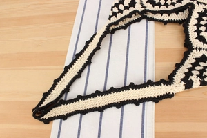 Detailed close-up of handmade crochet bag with black and white wavy knit pattern