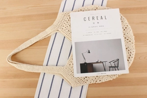 Detailed close-up of beige crochet knit beach bag texture on a rustic wooden table