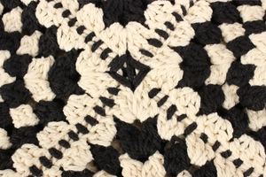 Macro detail of handmade crochet knit pattern with black and white floral texture