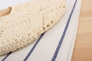 Detailed close-up of ivory crochet tote bag showing thick cotton rope hollow knit pattern