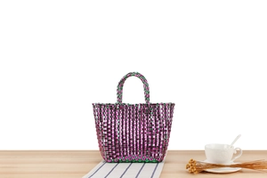 Détail d'un mini sac tissé à la main aux motifs texturés violets et verts métallisés