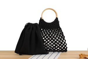 Close-up of black handmade macrame weave bag with natural round wooden handles