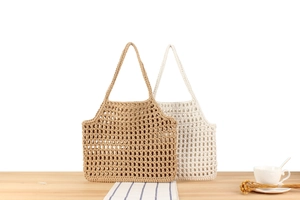 Close-up of hollow crochet tote bags in khaki and beige cotton rope for beach vacations