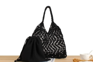 Close-up of black woven shoulder bag with mesh texture and inner drawstring pouch