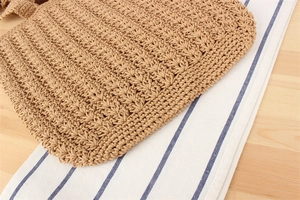Detailed close-up of brown crochet cotton rope pattern on a casual woven tote bag