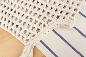 Close-up of beige hand-woven cotton rope bag featuring a hollow diamond mesh texture