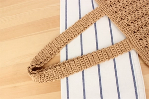 Detailed close-up of handmade hollow cotton rope crochet bag with intricate woven texture