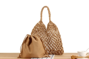 Detail of hand-woven mesh tote bag with cotton drawstring inner pouch and braided handle