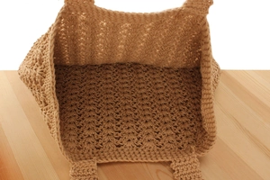 Detail view showing spacious interior and hollow crochet texture of the woven tote bag