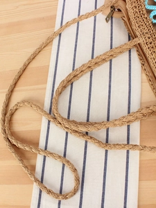 Handwoven straw crossbody bag with floral detail and sturdy strap for beach vacations