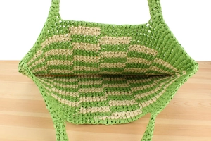 Top view of large woven straw tote bag showing spacious interior and green checkerboard texture