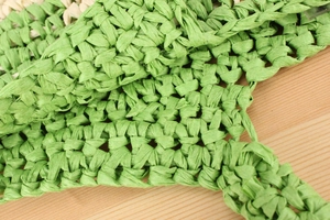 Close-up of green and beige paper straw weave detailing on a large shoulder bag