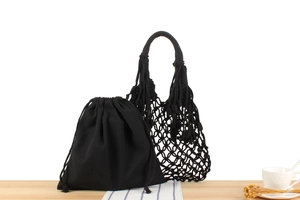 Detail of black hand-woven tassel shoulder bag with matching canvas drawstring inner pouch