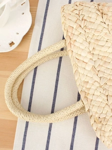 Minimalist corn husk woven handbag with round handles for beach vacations and casual use