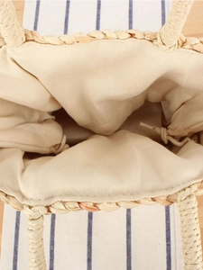 Straw woven tote bag with cream canvas lining and practical drawstring closure design
