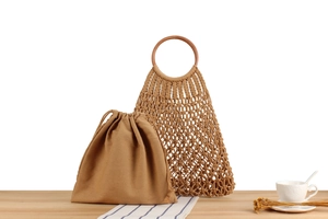 Detail of handmade macrame tote bag with wooden handles and canvas drawstring insert
