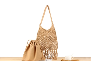 Détail du sac à bandoulière tissé à la main avec mailles évidées, pompons et pochette interne