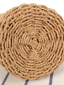 Bottom view of small woven straw bucket bag with spiral paper rope texture and wood beads