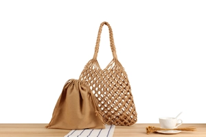 Detailed close-up of woven net shoulder bag with drawstring cotton inner pouch set