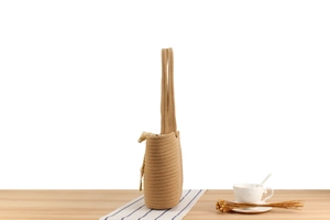 Détail du sac de plage tissé avec nœud beige et texture en corde de coton tressée