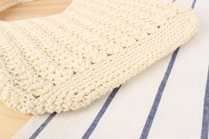 Close-up of beige cotton rope crochet bag showing intricate hollow weave texture
