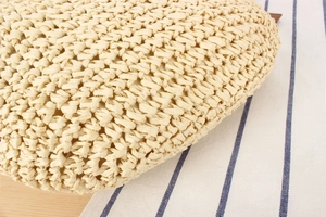 Macro detail of natural straw woven bag showing intricate herringbone pattern texture