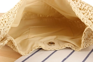 Detail view of woven paper rope bag with fabric lining, inner pocket and magnetic closure