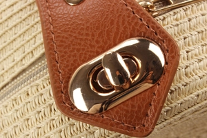 Macro detail of paper straw weaving texture with premium brown leather and gold metal lock