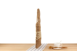 Détail du sac bandoulière en corde de papier tressée avec motif rayé et texture