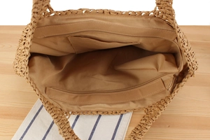 Détail de l'intérieur du sac en paille avec doublure kaki et poche intérieure zippée