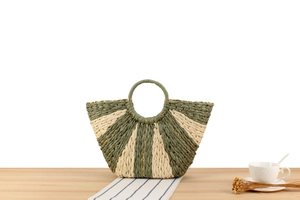 Detailed texture of green and beige paper rope woven handbag with gold metallic threads