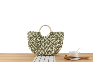 Detail of green and white woven paper rope texture on a stylish half-moon beach handbag