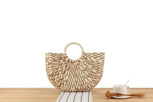 Detailed texture of two-tone woven paper rope handbag with round handles and boho style