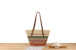 Detail of bohemian paper straw tote with colorful stripes and leather straps on table
