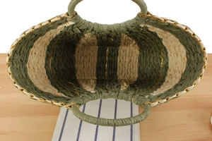 Close-up of olive green striped woven paper rope bag with metallic gold accents