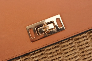 Detail of premium golden twist-lock closure on tan leather bag with fine stitching