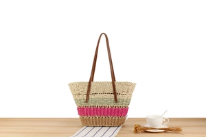 Detail of colorful paper rope woven tote with striped pattern and leather straps